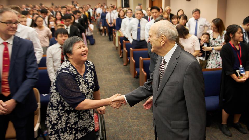 Church President Russell M. Nelson greets Susan Chan following a devotional held in Singapore 