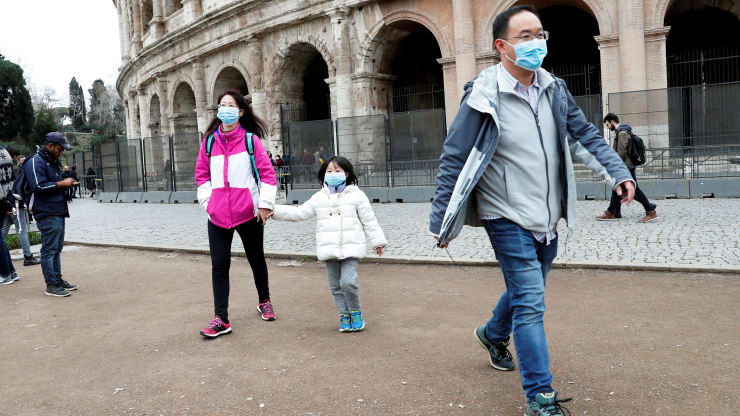 Tourists wearing protective masks walk past the Colosseum, after two cases of coronavirus were confirmed in Italy, in Rome, January 31, 2020.
Remo Casilli | Reuters
